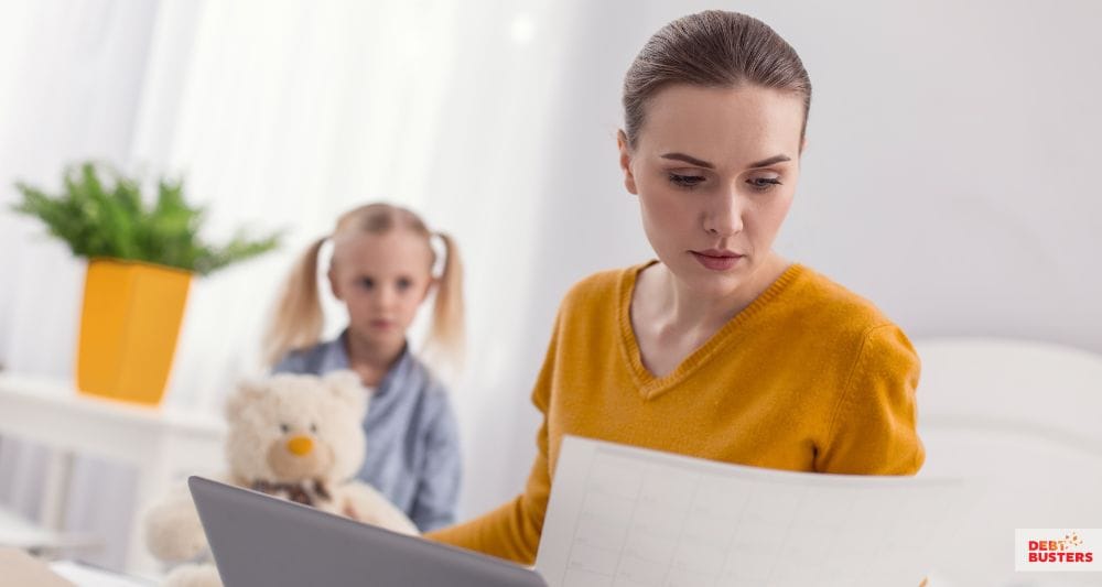 Worried mother reviewing bills, highlighting financial hardship grants for single mothers Australia support needs.