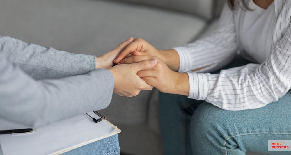 Two women holding hands in support, symbolising financial hardship grants for single mothers Australia.