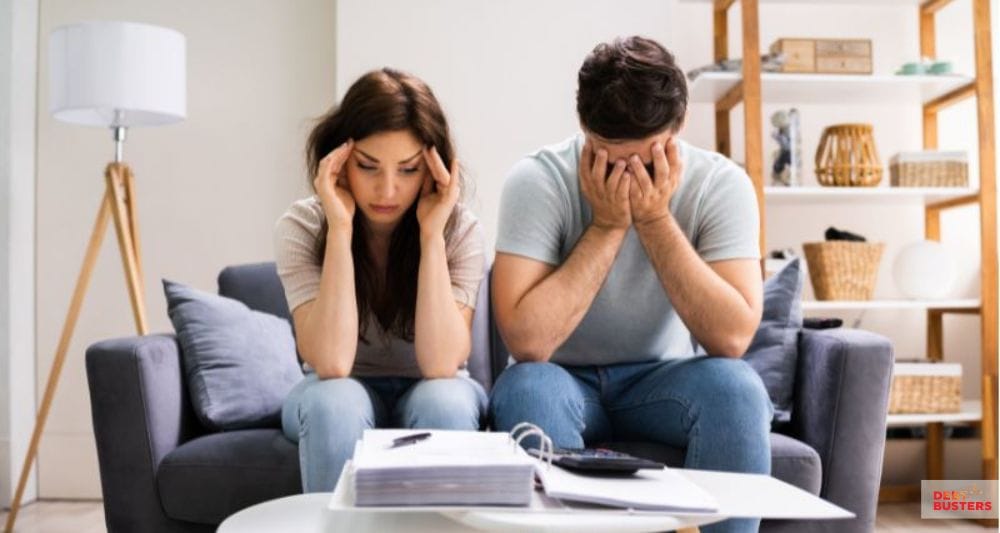 Stressed couple reviewing bills, illustrating financial strain