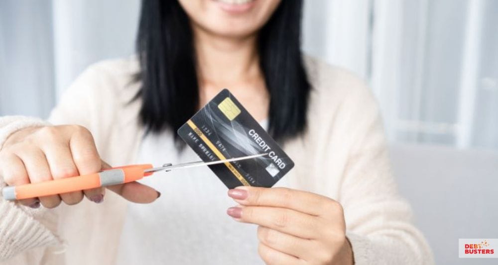 Woman cutting credit card, representing debt relief