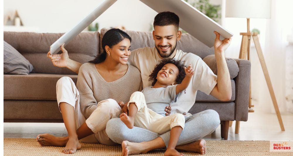 Happy family under cardboard roof, symbolizing fresh start after experiecing bankruptcy 
