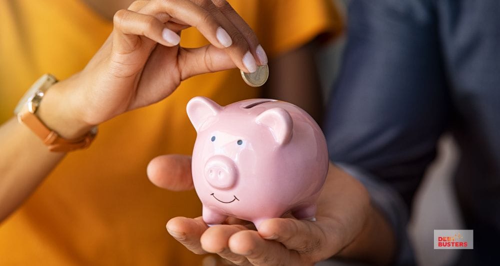 Hands saving coin in piggy bank, representing financial planning amid mortgage stress in Australia families.